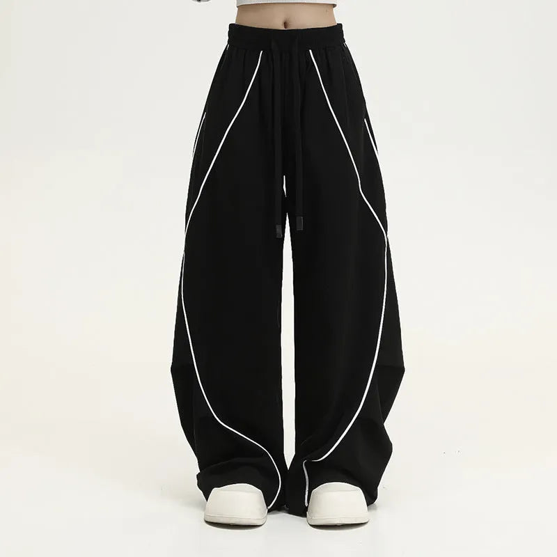 Black and white striped wide-leg hip hop sports trousers with pleats, shown laid flat.