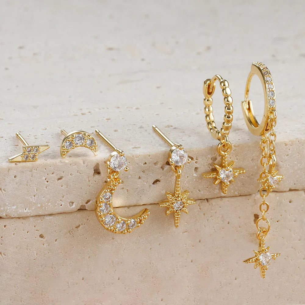 Six pairs of gold electroplated chain tassel earrings with zircon studs on display