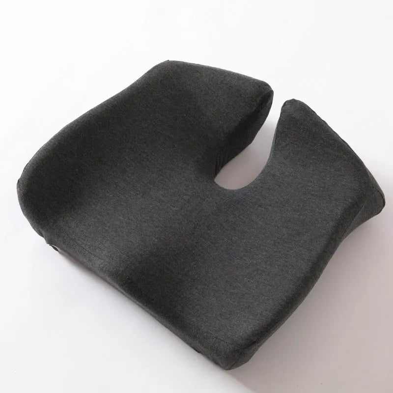 Dark grey memory foam office chair cushion with contoured shape for lower back support on a desk chair.