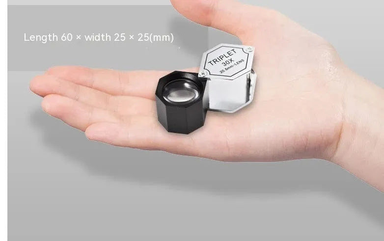 Handheld metal magnifying glass with optical lens for jewellery and stamp identification.