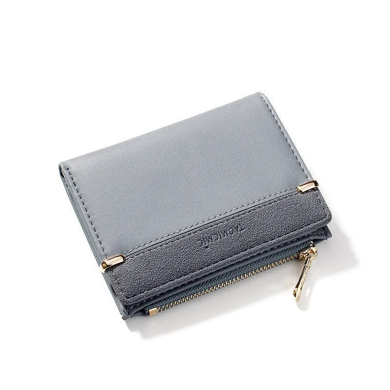 Black ladies folding wallet with a short zip, open to show multiple card slots, bill holder, and change compartment.