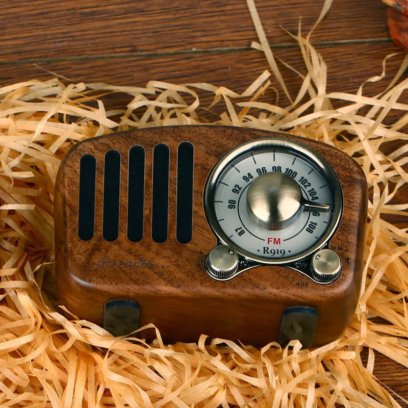 Compact retro wooden wireless Bluetooth speaker in cherry wood finish on a wooden table
