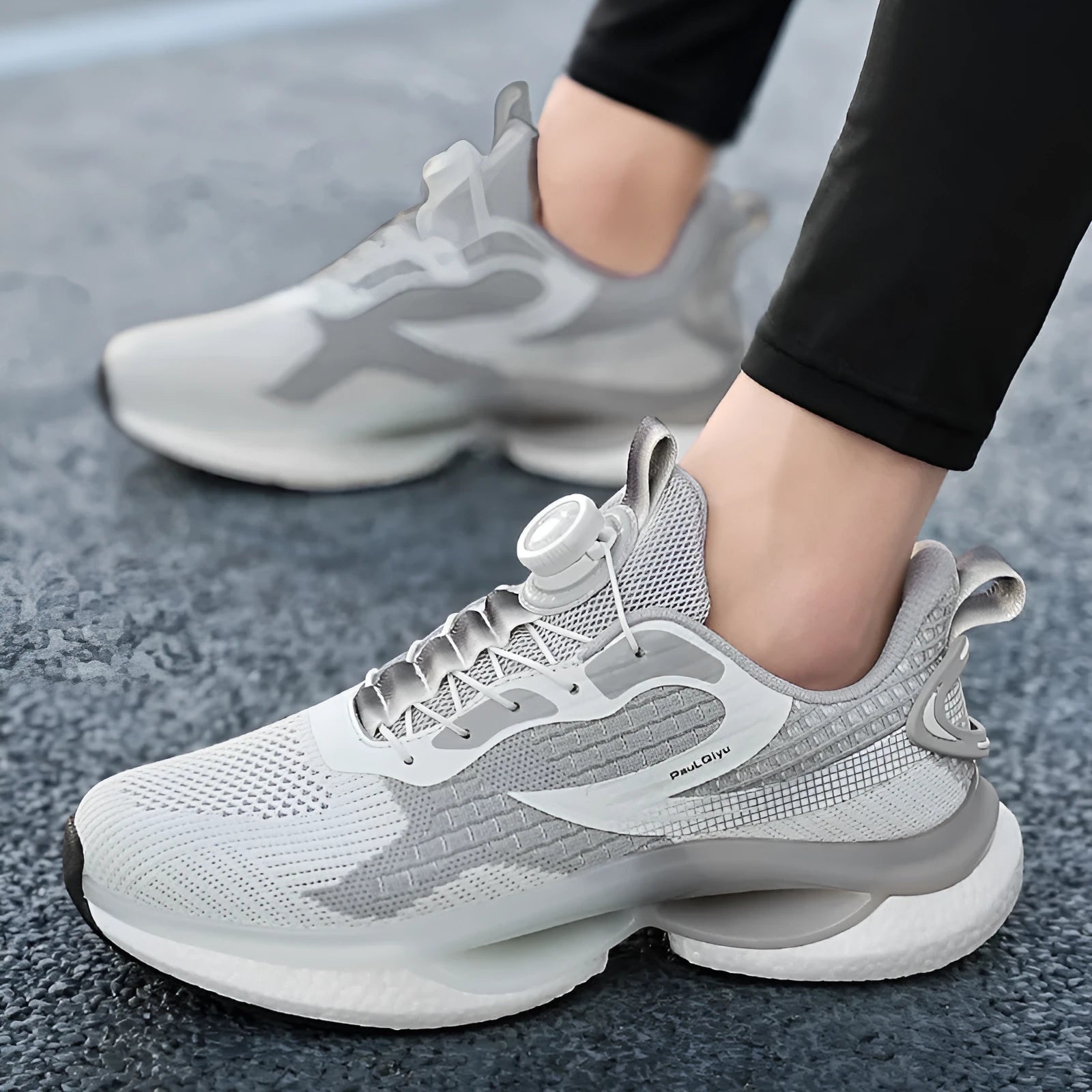 White rotating buckle low-top running shoes with breathable fly-knit mesh upper on a grey background.