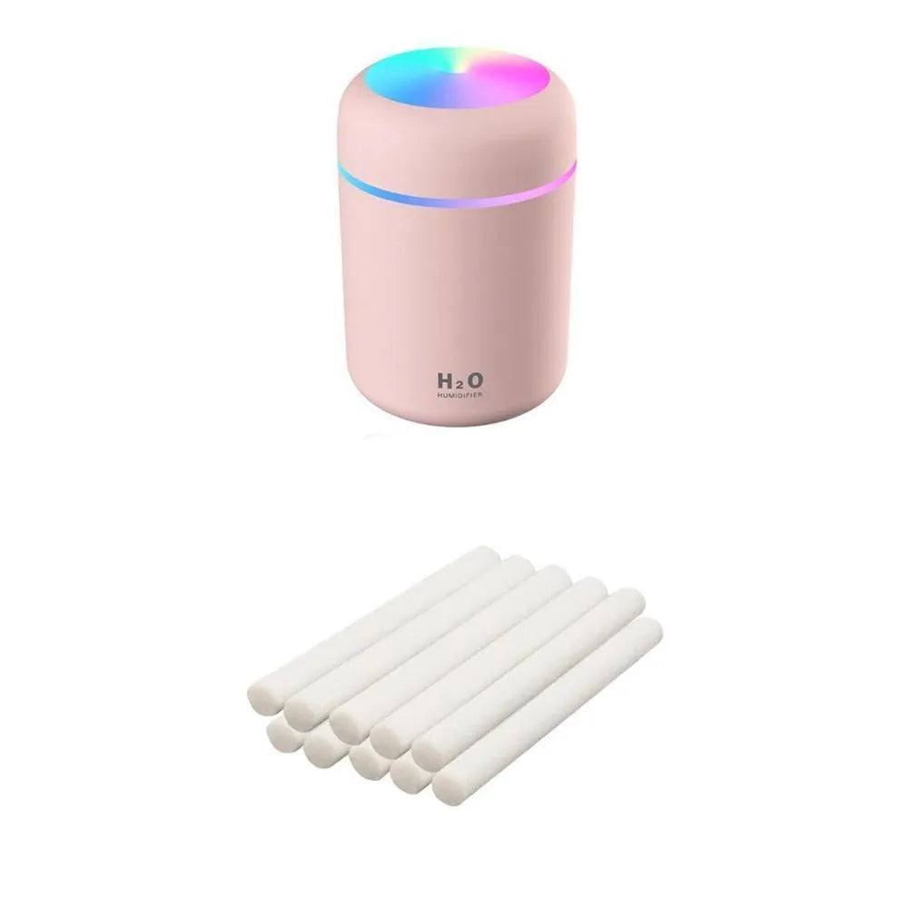 Pink USB desktop humidifier with coloured lights and water tank on a wooden desk
