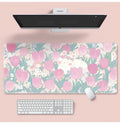 Large flower pattern mouse pad on a desk with keyboard, showing non-slip rubber base and colourful tulip design.