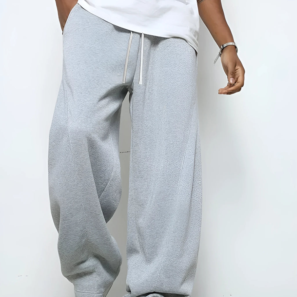 Man wearing solid-colour straight-leg polyester casual trousers with a drawstring waist.