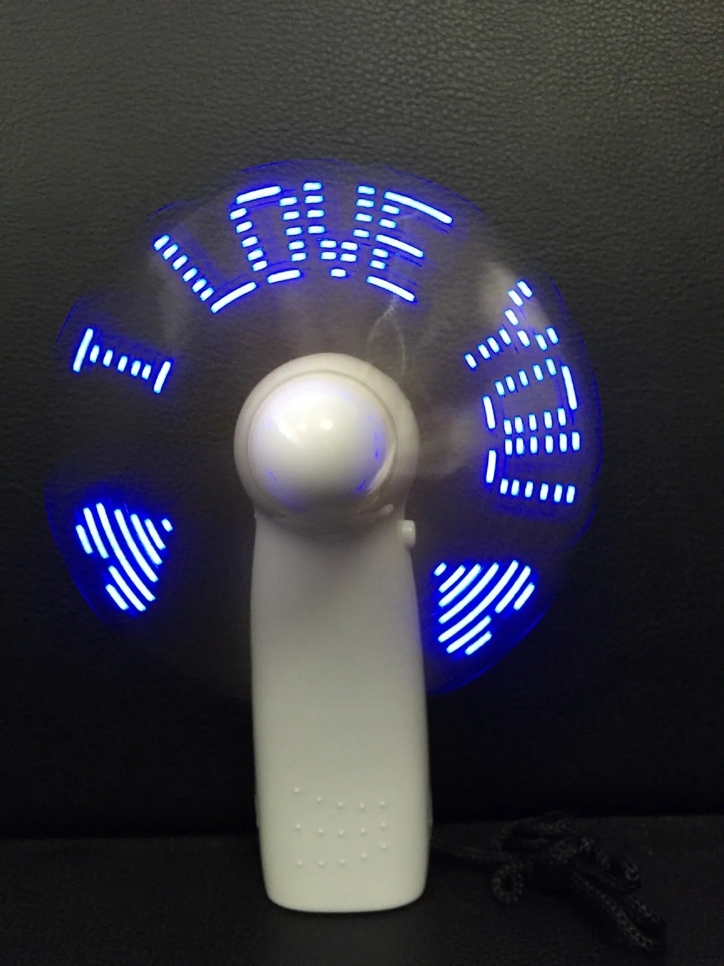 White handheld mini fan with LED lights displaying love pattern and I love you message