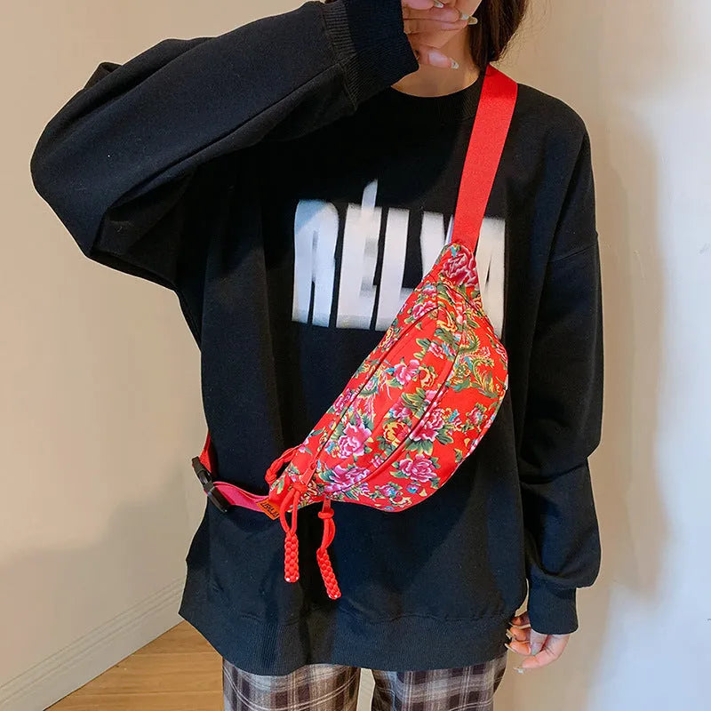 Women's black waist bag with large red flower design and western stitching details.