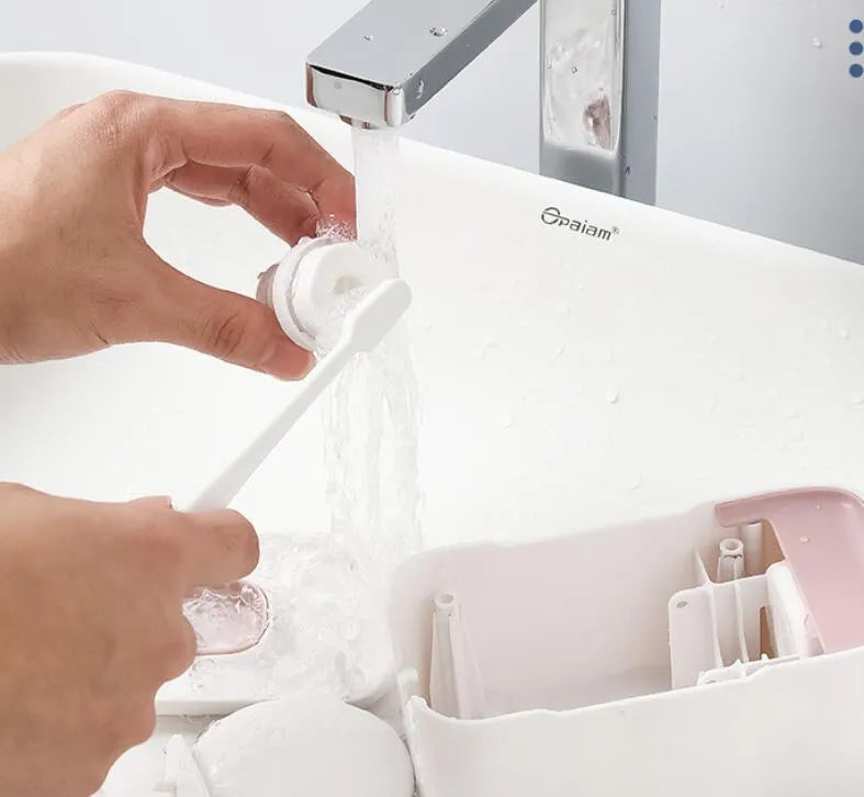 Automatic wall-mounted toothpaste dispenser in blue, grey, and pink colours with USB charging cable.
