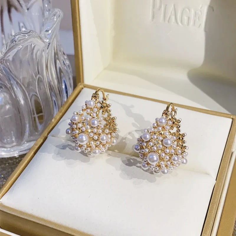 Gold-coloured copper flower basket earrings with small bead and pearl inlay detail.