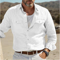 A man wearing a loose-fit, long-sleeved shirt in a solid colour, made from cotton and linen fabric.