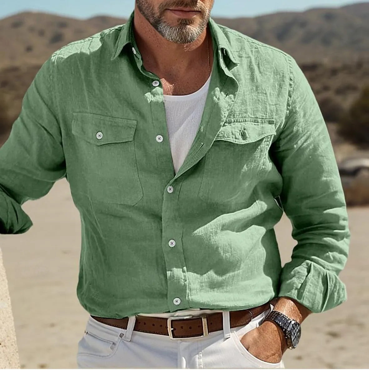 A man wearing a loose-fit, long-sleeved shirt in a solid colour, made from cotton and linen fabric.