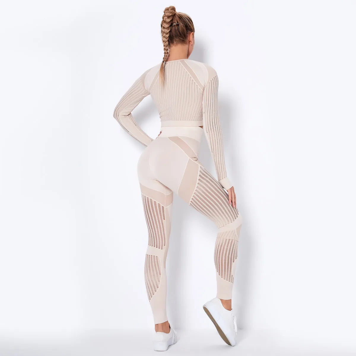 Woman wearing a long-sleeved seamless knitted yoga wearsuit in a stripe pattern, demonstrating a yoga pose.