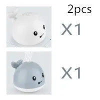 White and blue whale-shaped bath toy with water spray and LED lights floating in water