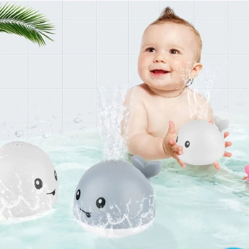 White and blue whale-shaped bath toy with water spray and LED lights floating in water