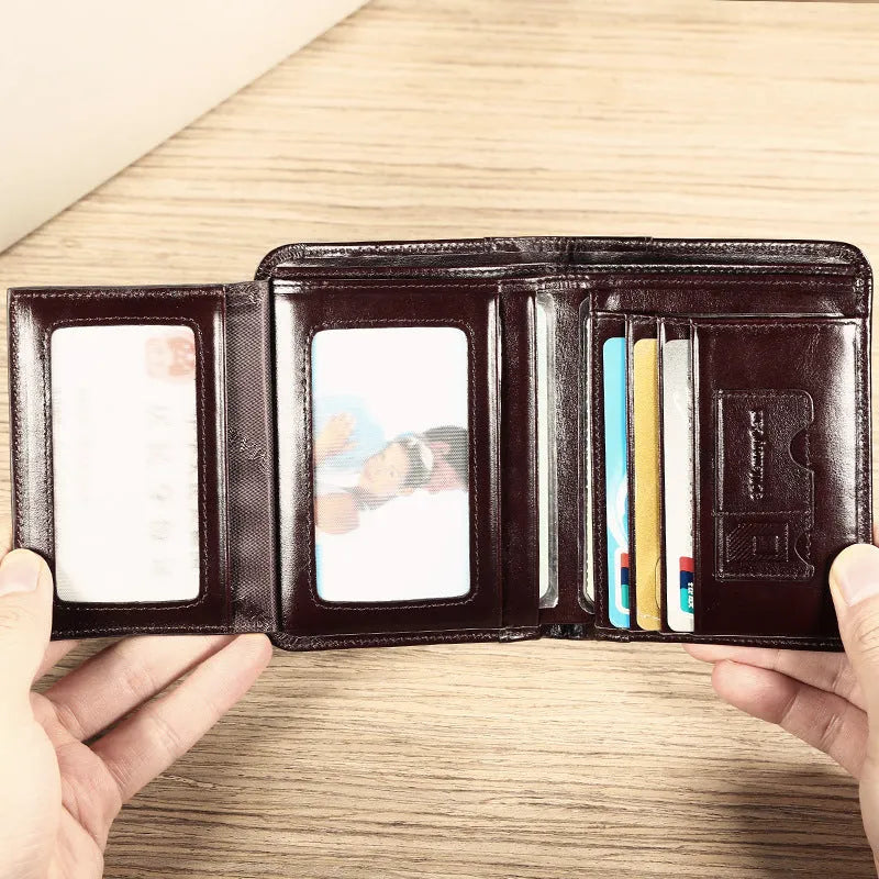 Men's black leather bifold wallet open to show internal card slots, photo window, coin pocket, and banknote compartment.