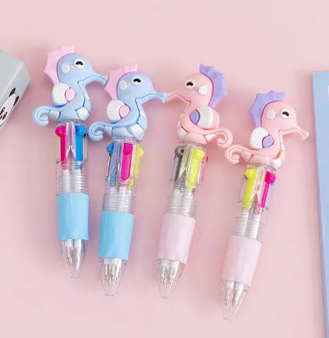 A four-colour ballpoint pen with a press top and a colourful cartoon silicone grip, showing one of five random designs.