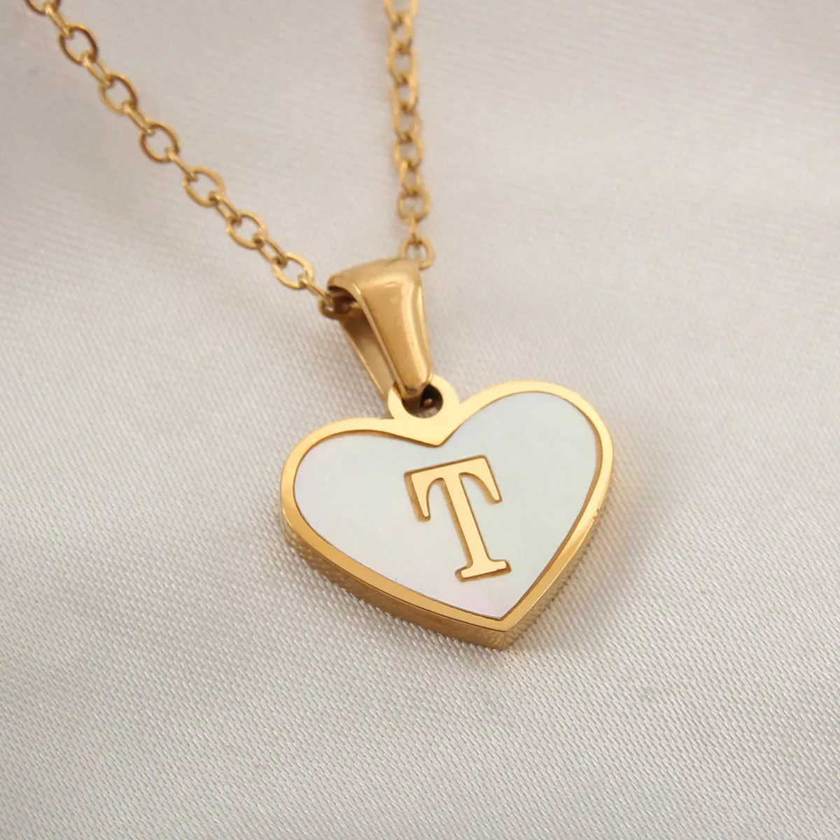 Gold plated heart-shaped white shell pendant personalised initial necklace on a stainless steel chain.