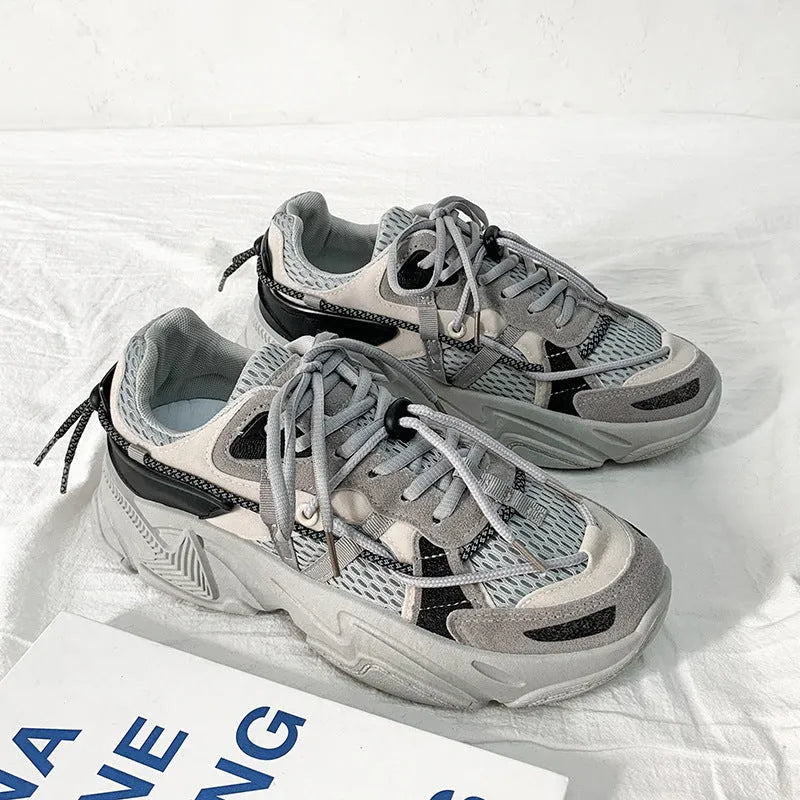 Men's white platform dad sneakers with a lace-up front and thick sole, shown on a grey background.