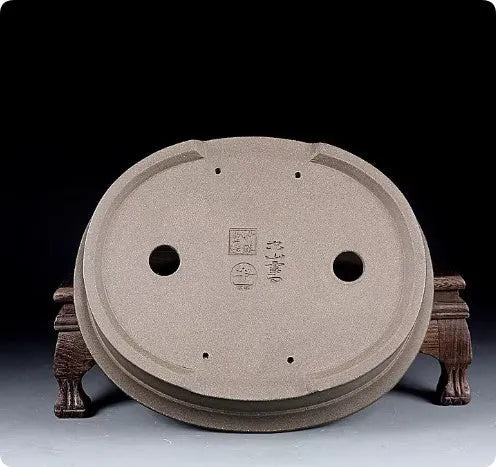 Handmade antique oval purple sand ceramic bonsai pot on a surface.