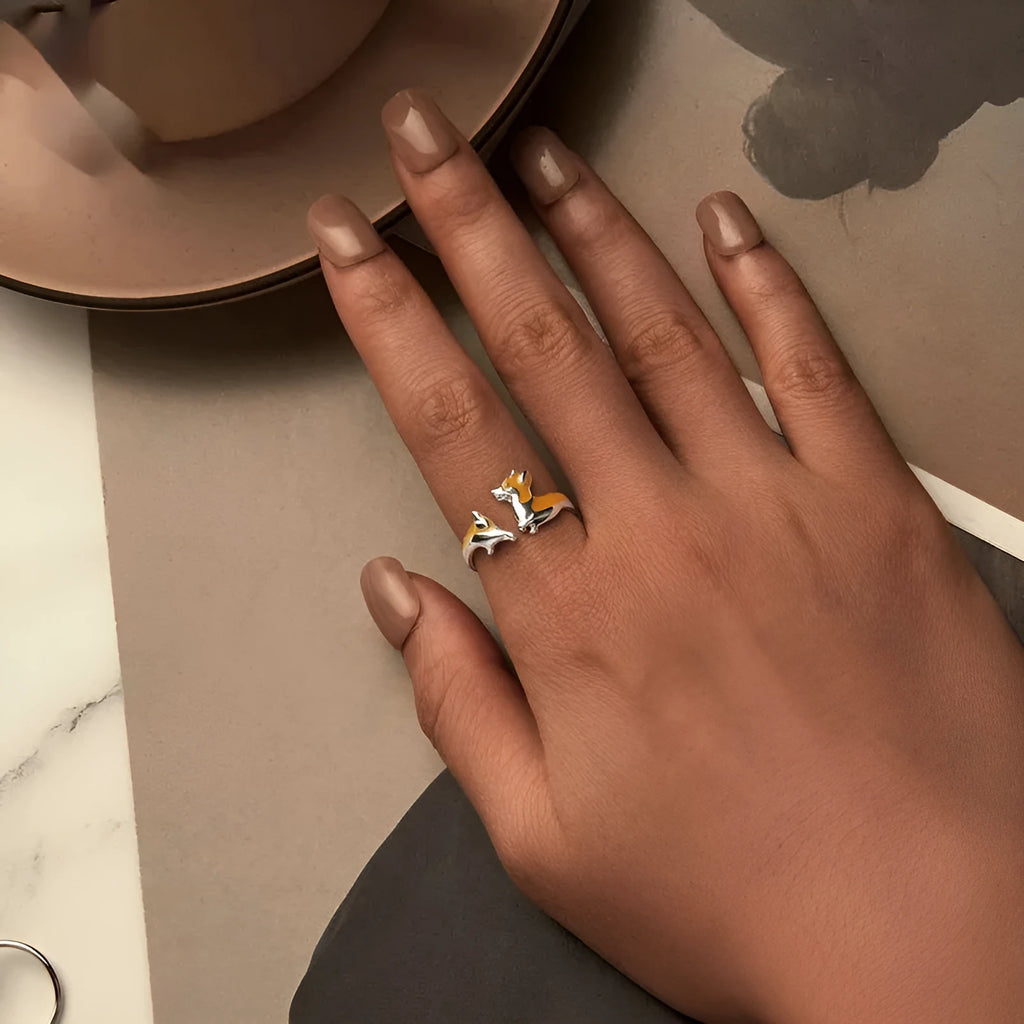 Silver corgi pet cartoon ring with electroplated colour on a model's finger.