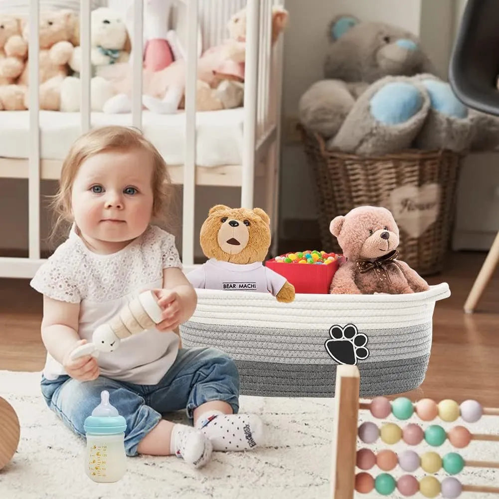 Light beige handmade cotton rope storage basket with wooden handle on a table.