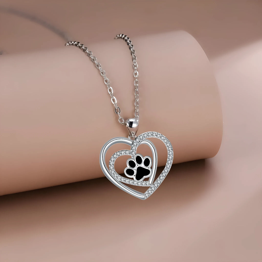 Women's necklace with a heart-shaped dog paw print copper pendant on a cross chain.