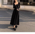 Women's black knitted dress with square collar and elastic waistband showing A-line long skirt design