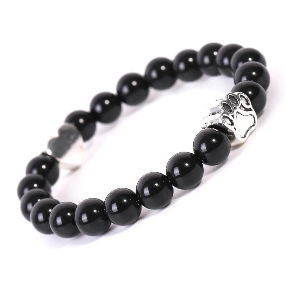 A round beaded stone bracelet in a Tiger Eye or Indian Agate style on a wrist.
