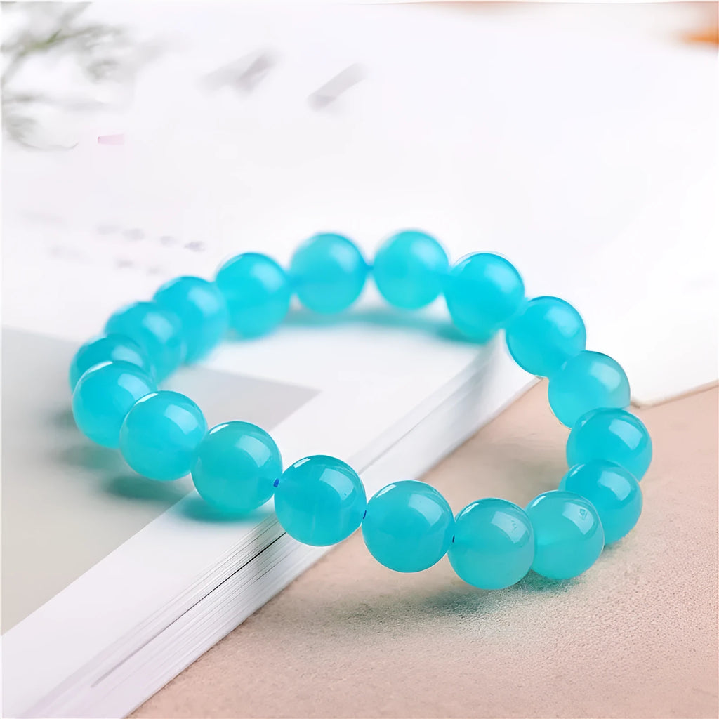Polished natural Amazonite scattered beads in blue-green ice colours on a white background, showing different sizes from 6mm to 13mm.