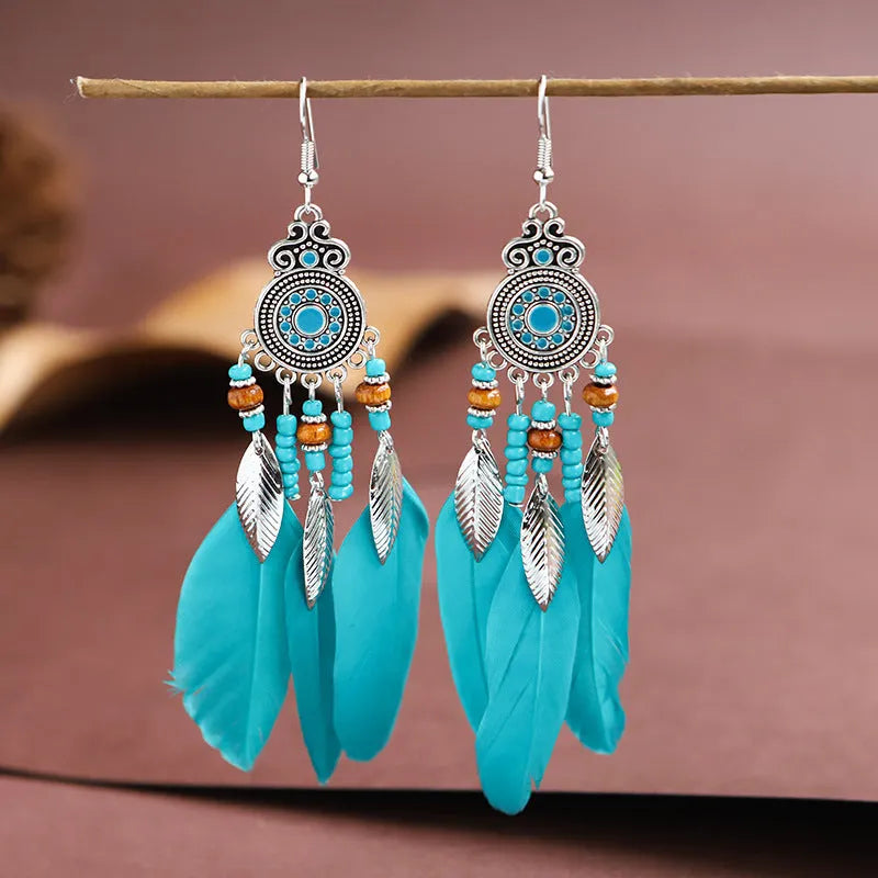 A pair of bohemian-style round drop earrings with a feather leaf pattern, shown in one of thirteen available colours.