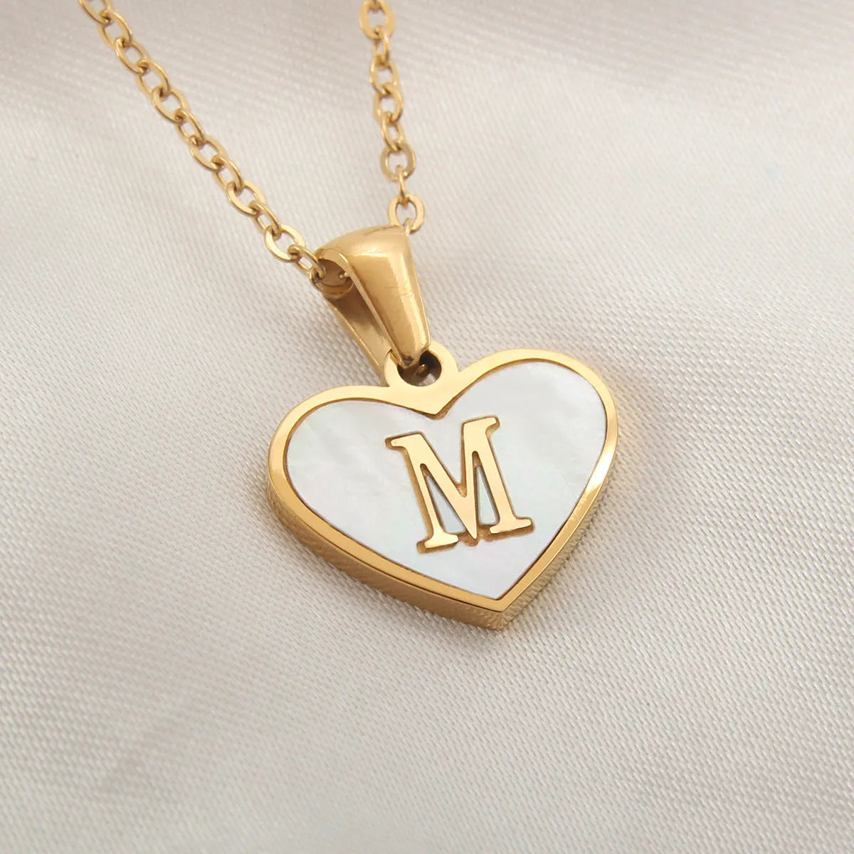 Gold plated heart-shaped white shell pendant personalised initial necklace on a stainless steel chain.