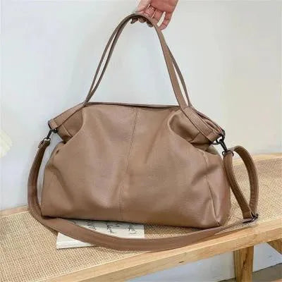 Large soft PU leather messenger bag with adjustable strap in black, shown open with internal pockets.