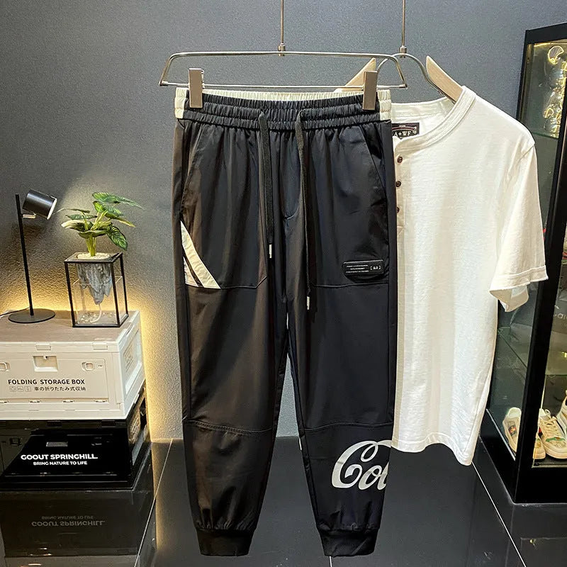 Men's black cropped trousers with ankle banding in ultra-thin ice silk fabric laid flat to show casual design.