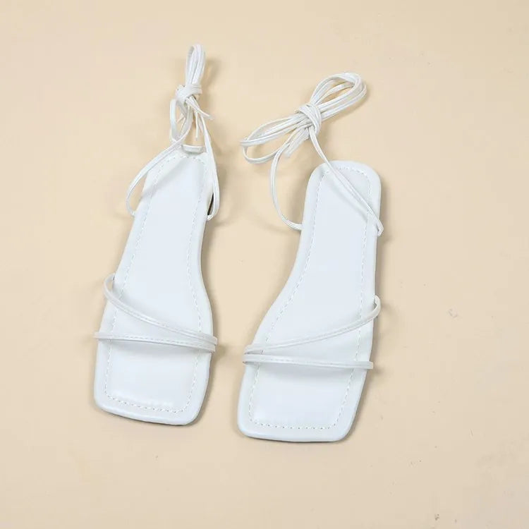 Women's flat sandals with ankle bandage cloth and lace-up closure in black, orange, or white.