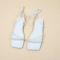 Women's flat sandals with ankle bandage cloth and lace-up closure in black, orange, or white.