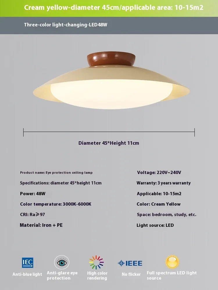 Modern minimalist flying saucer design ceiling lamp in cream yellow on a white ceiling.