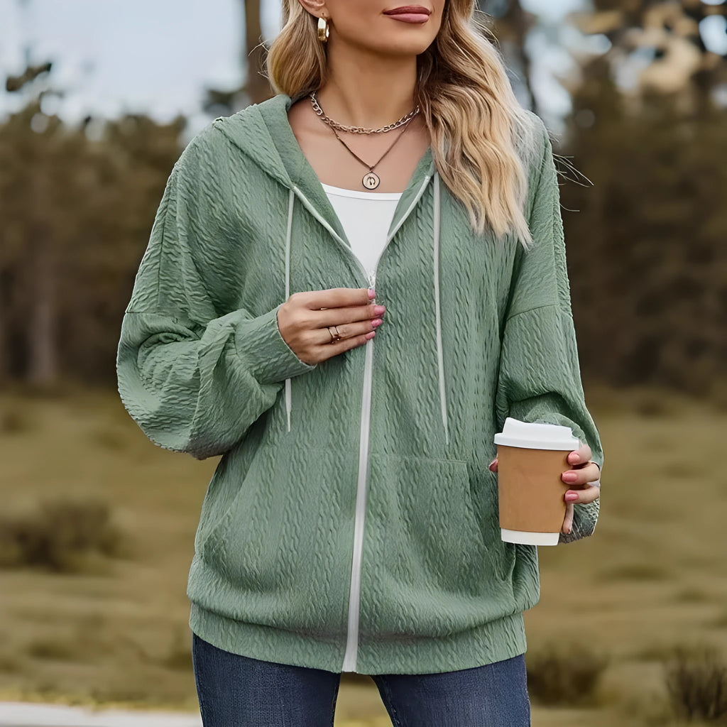Green women's loose-fit hooded zip-up jacket on a hanger