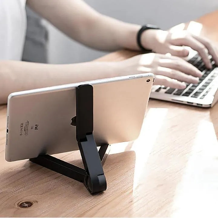 Black foldable tablet holder holding a smartphone in landscape mode on a desk.