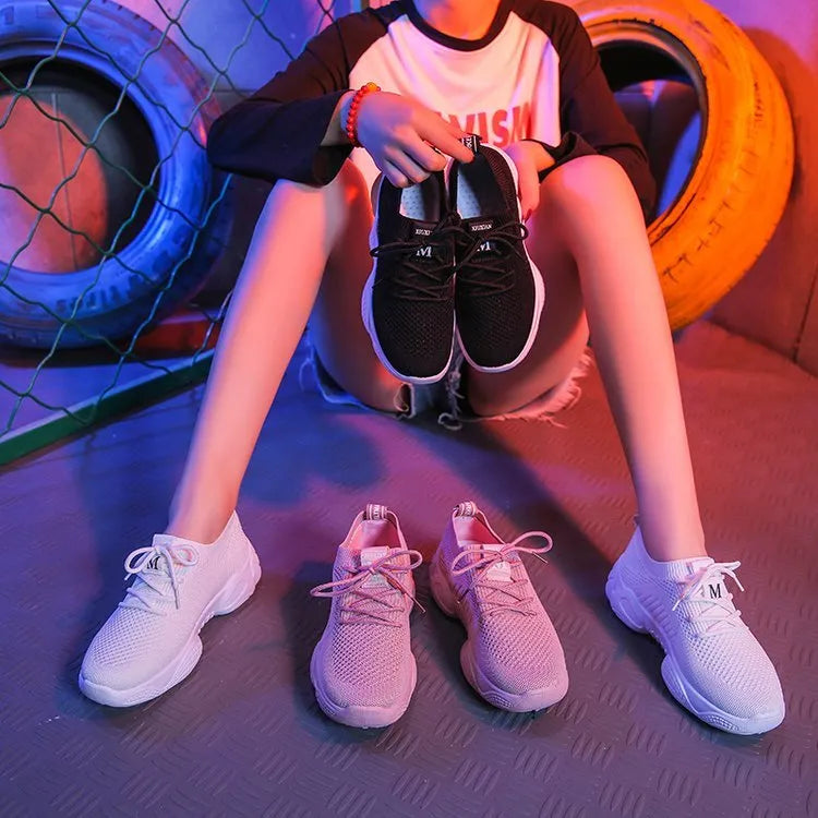 Women's white sports shoes with thick rubber soles and woven upper featuring lace-up front strap