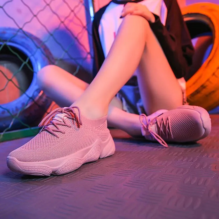 Women's white sports shoes with thick rubber soles and woven upper featuring lace-up front strap
