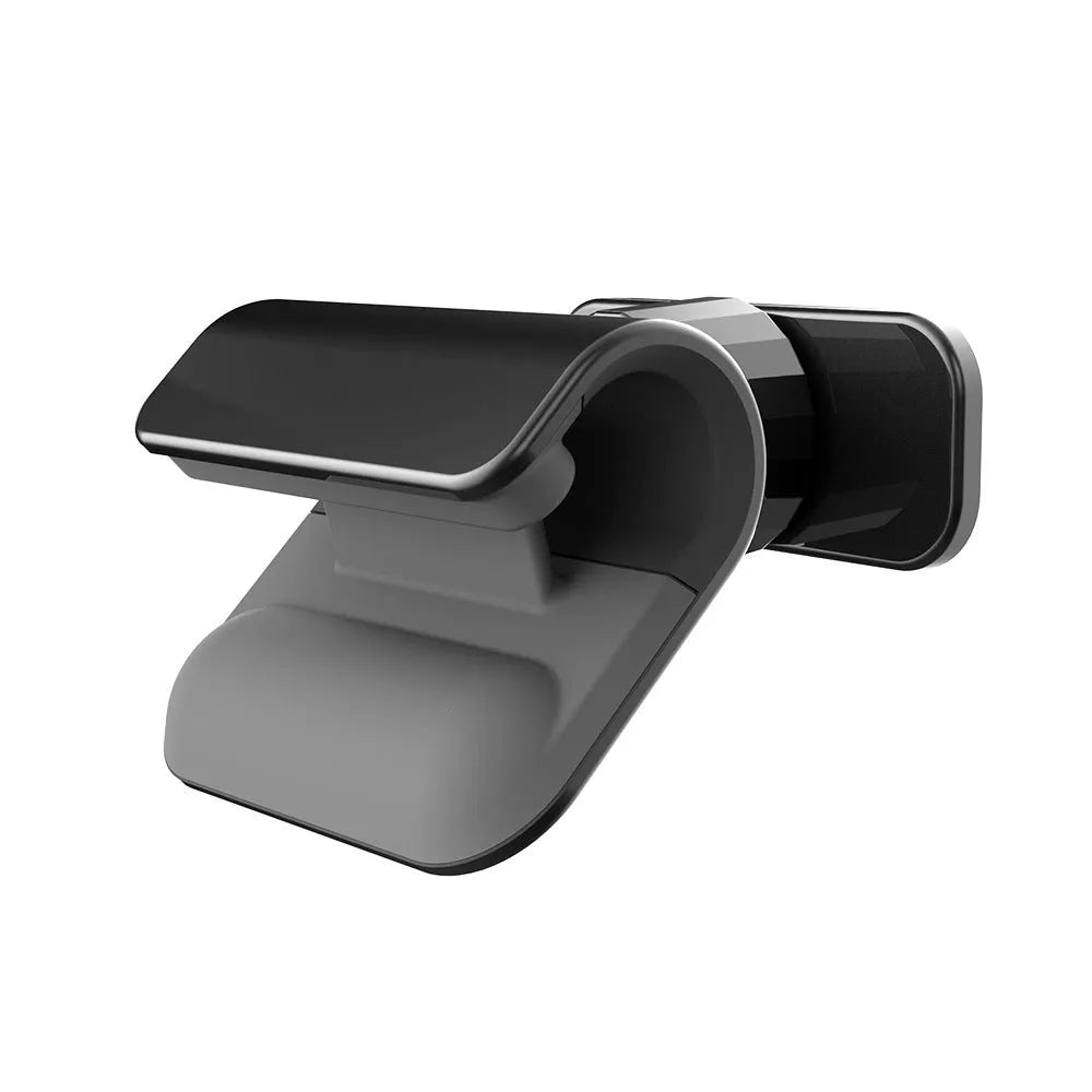 Black universal gravity car phone holder with 360-degree rotating head on a car dashboard.