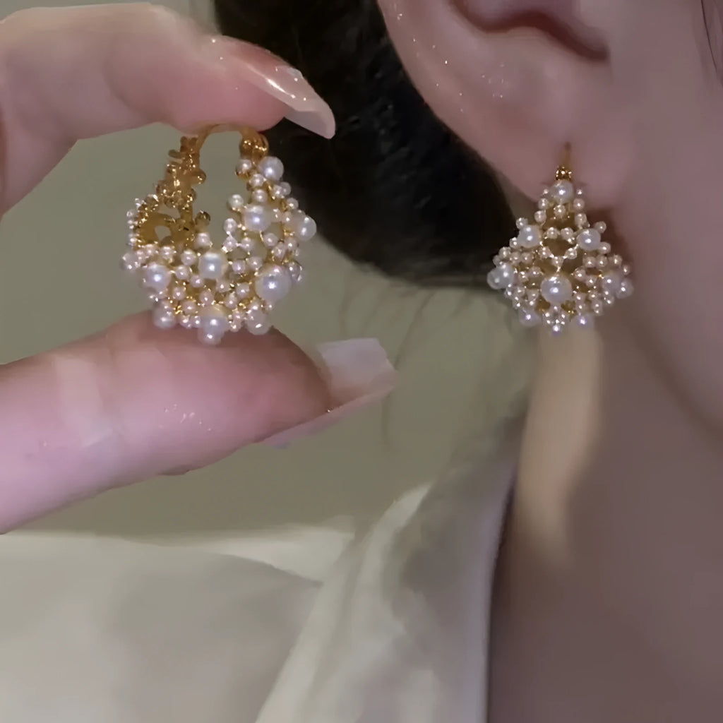 Gold-coloured copper flower basket earrings with small bead and pearl inlay detail.