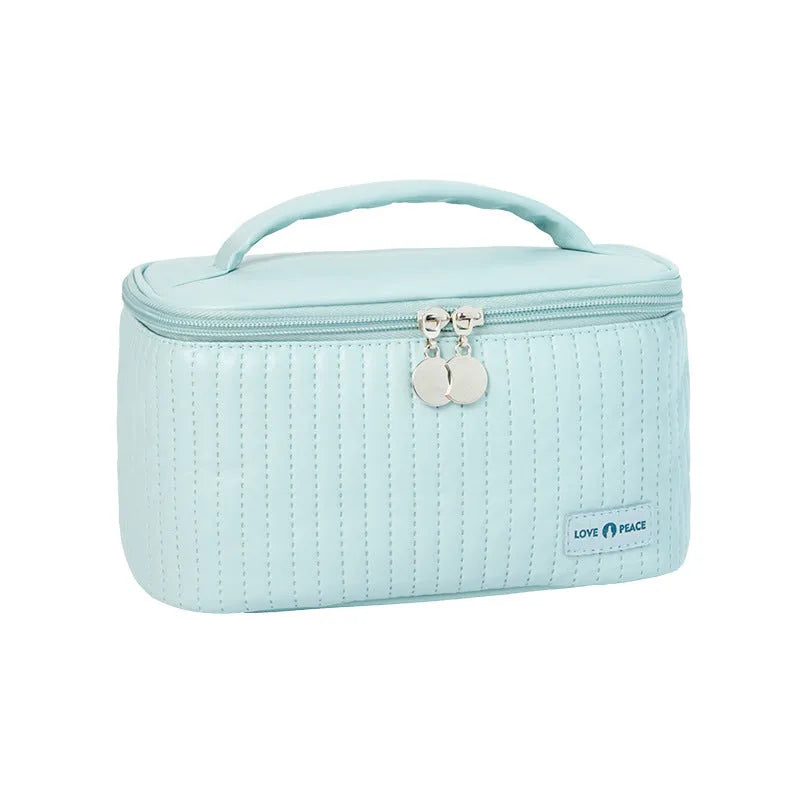 Open-top cake shaped makeup bag in solid colour PU leather, shown in a light blue colour variant.