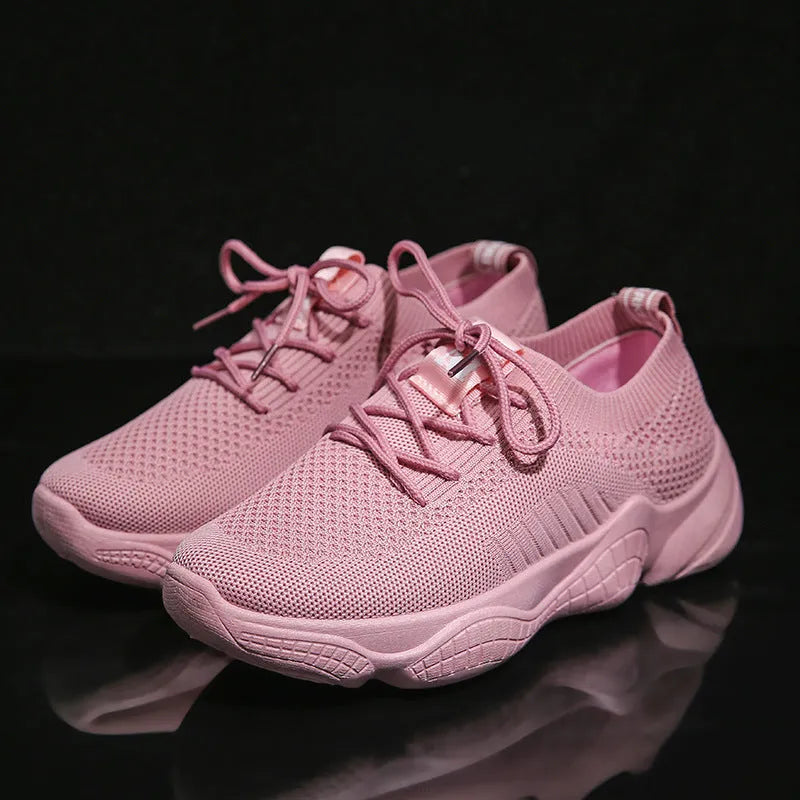 Women's white sports shoes with thick rubber soles and woven upper featuring lace-up front strap