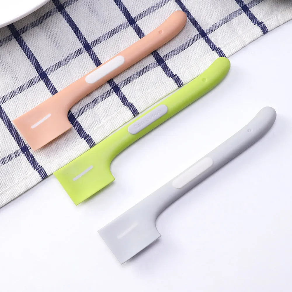 Green long-handle pet feeding spoon for canned cat and dog food on a white background.