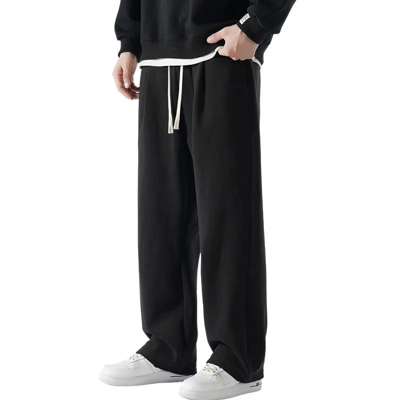 Men's thick apricot coloured fleece-lined loose fit casual sports trousers on a hanger.
