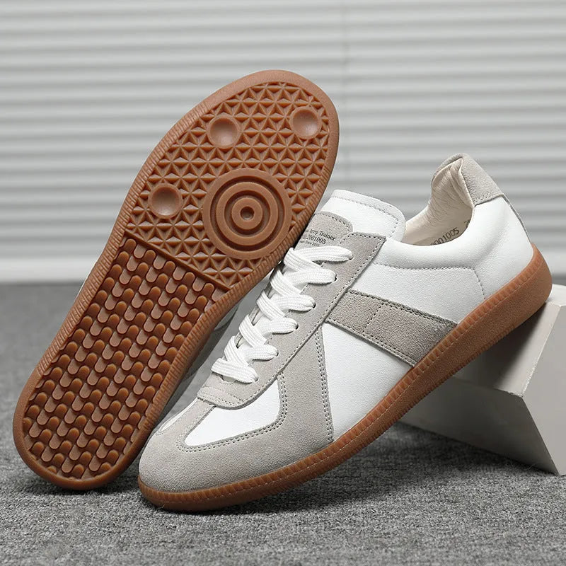 White retro unisex board sneakers with lace-up front and round toe on a rubber sole.