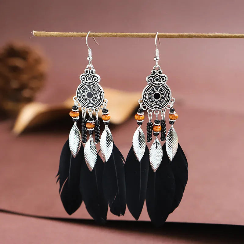 A pair of bohemian-style round drop earrings with a feather leaf pattern, shown in one of thirteen available colours.