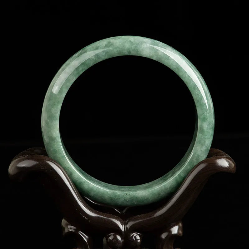 Natural emerald bean green bracelet on wrist, showing simple band and deep green gemstone.